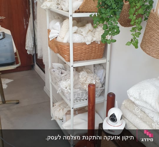 מצלמת אבטחה לבנה על מדף ליד בדים